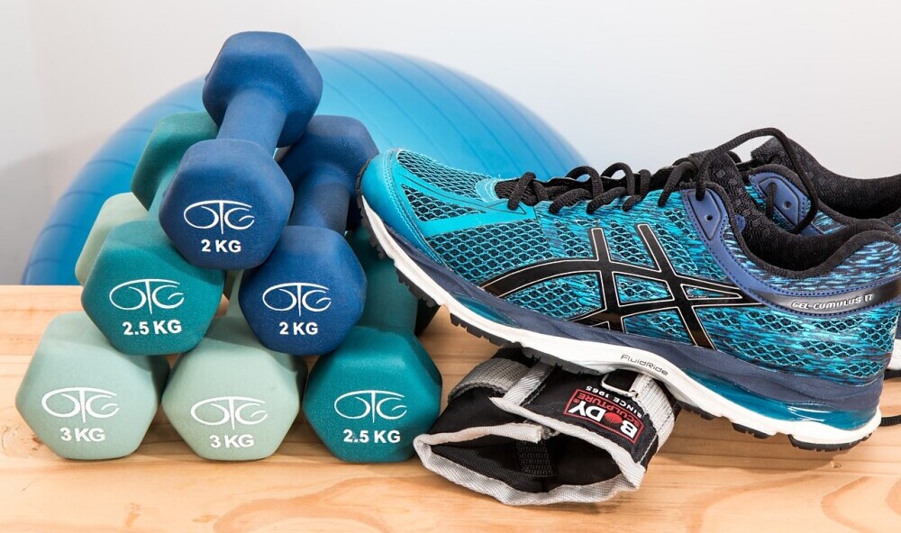 how to get motivated to exercise display of dumbells and workout shoes.